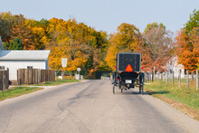 Amish Buggy Shot From Behind As It Travels Down A Country Road In The Fall