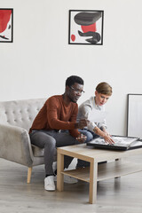 Wall Mural - Vertical portrait of African-American man talking to female art gallery manager while discussing paintings and planning exhibition in museum