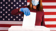 Woman voting with gloves and face mask at coronavirus pandemic. 2020 United States presidential election.