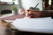 © Gajus - Woman writing in blank notebook on wooden desk