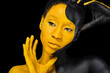 © Mike Orlov - Face art. Woman with black and yellow body paint. Young african girl with colorful bodypaint. An amazing model with yellow makeup. Closeup face.