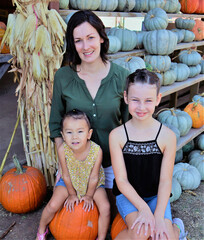 mother and kids with pumpkins at the pumpkin patch