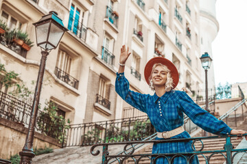 Wall Mural - Happy, smiling tourist woman wearing stylish autumn blue checkered dress, orange hat, wide white belt, posing in street of Paris. Copy, empty space for text