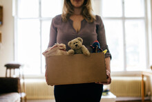 Woman Holding Box Filled With Childrens Toys