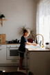 © Елена Лавринович - A boy of European appearance washes his hands in a light kitchen at home.
