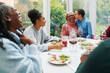 © IVAN GENER/Stocksy - Girl kissing her grandma during dinner