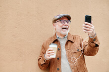 Senior Man Laughing And Using A Cellphone