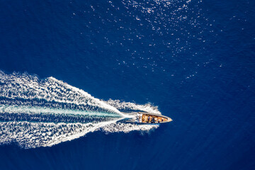 Wall Mural - aerial top down view of a rib motorboat traveling over blue sea