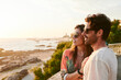 © IVAN GENER/Stocksy - Smiling couple watching an ocean sunset