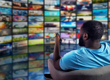Man Has Fun Watching A Film. Concept Of Entertainment And Streaming Tv. Red Background