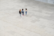 Three Women In Face Masks Walking In A Square