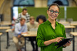 © Friends Stock - Portrait of young happy asian woman using digital tablet, looking at camera and smiling while standing in the coworking space with colleagues on the background