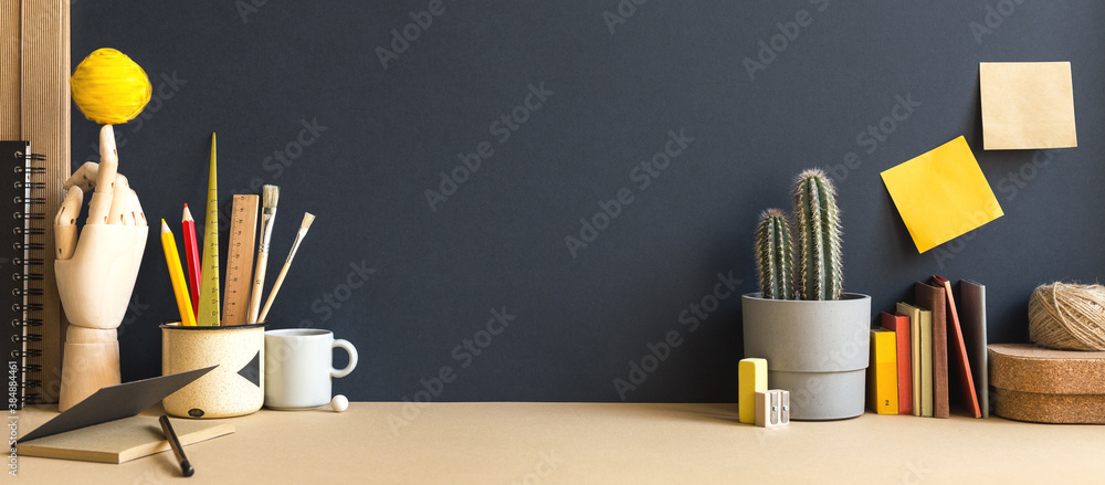 Creative desk with notebook, desk objects, office supplies, books, and cactus on a dark blue background.	
 - obrazy, fototapety, plakaty 