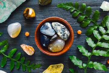 Wall Mural - Bowl of Agate and Zodiac Stones of Gemini on Blue Background