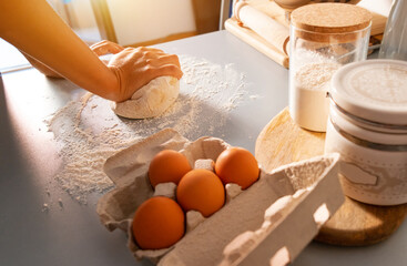 Unrecognized woman kneading the dough for bread with flour around on kitchen table. Homemade food concept. Food preparation. Cooking bread.