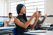 © kleberpicui - College students recording the lecture in classroom with their cell phones.