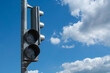 © Ramil - Switched off grey traffic light against bright blue cloudy sky background with copy space. Offline streetlight signal in the city crossroad. Urban traffic system problems due to deactivate semaphore.