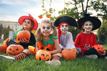 Sticker - Cute little kids with pumpkins wearing Halloween costumes in park