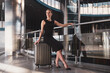 © zinkevych - Woman sitting on a suitcase while waiting in the airport