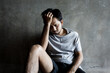 © anut21ng Stock - Young asian man Sitting and feeling stressed in the dark with little light in the corner