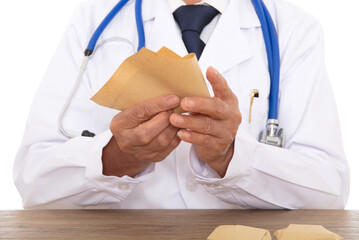 The doctor in a white coat is wrapping the medicine in straw paper