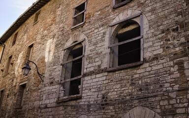 Wall Mural - Windows without glasses and shutters of an abandoned medieval building with stone walls (Gubbio, Umbria, Italy, Europe)