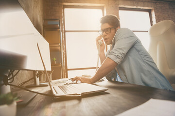 Portrait of his he nice attractive busy overwhelmed guy digital manager answering calls solving web site problem at modern industrial interior loft brick style workplace workstation