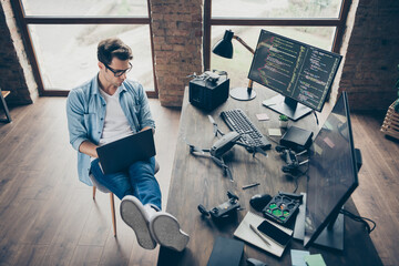 Above high angle view of his he nice attractive focused guy geek expert working remotely typing coding calculating game development dev at modern industrial home office work place station