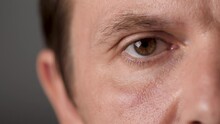 Man's Brown Eyes Looking Into The Camera. Male Eye No Blinking. Focused Man Gazing On Something. Close Up. Male Eyeballs. Caucasian Man Half Face. Guy Looks Intently. Natural Beauty. 30-40 Years