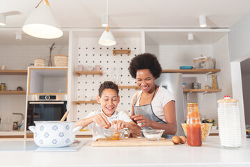 Mother and son cooking with eggs in kitchen