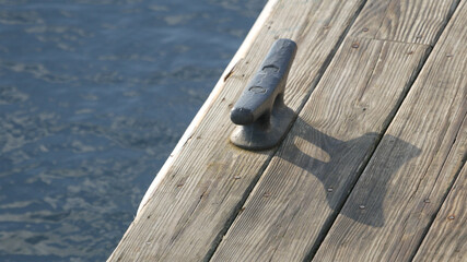 Dock cleat fastened to a floating dock on the sea.