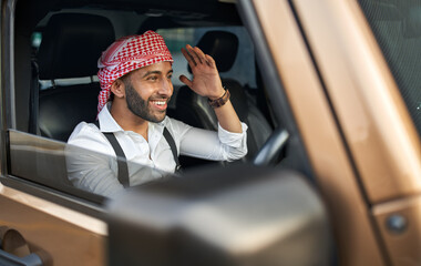 Wall Mural - Indian arab business man wearing traditional Keffiyeh head scarf driving car