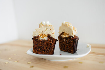 cut chocolate cupcake with caramel cream on a white saucer