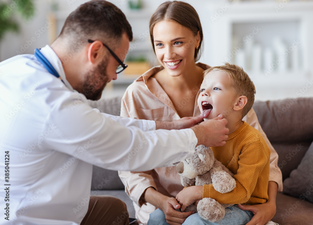 family doctor pediatrician conducts examination of   child boy with his mother, looks at his throat   .