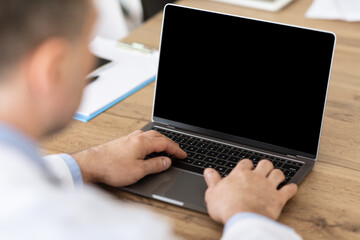 Man working on laptop with empty black screen for mockup