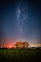 Landscape image of milky way over the abandoned twin house near Chalerm Phra Kiat road in Thale Noi, Phatthalung, Thailand