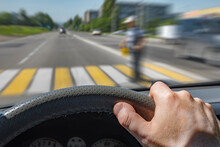 The Driver Hand On The Steering Wheel Of A Car Moving At High Speed And Passing A Pedestrian Crossing With The Risk Of Hitting A Person