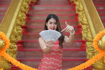 Wall Mural - Beautiful Asian woman holding lots of money US dollar in Chinese New Year