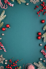 christmas frame with classic decorations. fir branches, red balls, jingle bells on turquoise backgro