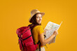 © Prostock-studio - Smiling young woman tourist with backpack holding city map