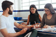 © kleberpicui - Multiethnic group of college students talking in classroom.