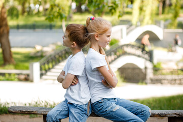 Children take offense at each other in the park on a bench.