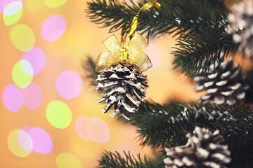 Canvas Print - Christmas fir tree with cones on blurred lights background