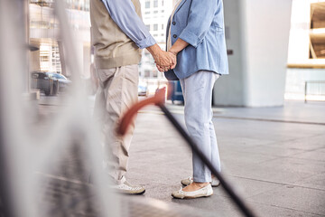 Wall Mural - Two romantic elderly people holding hands outdoors