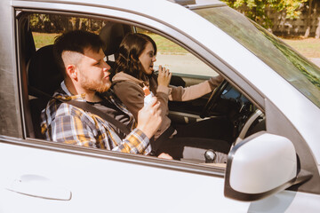 Wall Mural - couple having chocolate snack while riding in car