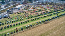Aerial View Of An Amish Mud Sale With Lots Of Buggies And Farm Equipment