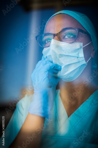 Fototapeta Young female medic, wearing a mask and glasses