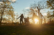 © Dann - Disabled teen jumping into pile of leaves with a group of his friends.