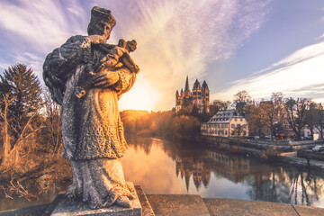 the cathedral in limburg germany. nice view over an old bridge with statue and the river at sunrise