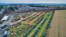 Aerial View Of An Amish Mud Sale With Lots Of Buggies And Farm Equipment On A Winter Day